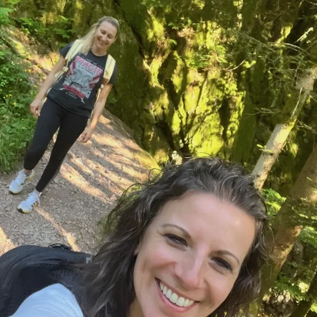 lächelnde Frauen sind wandern im Wald